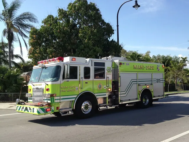A lime-green fire engine on a palm-lined street