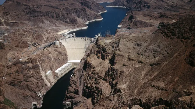 Hoover Dam seen from above, with Lake Mead behind it and the Colorado River canyon below