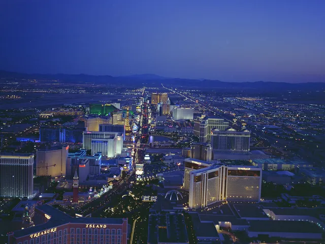 The Las Vegas Strip at dusk, seen from above with hotel towers lit up