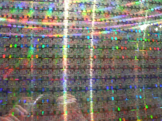 Close-up of a silicon wafer with rainbow reflections from its etched chips