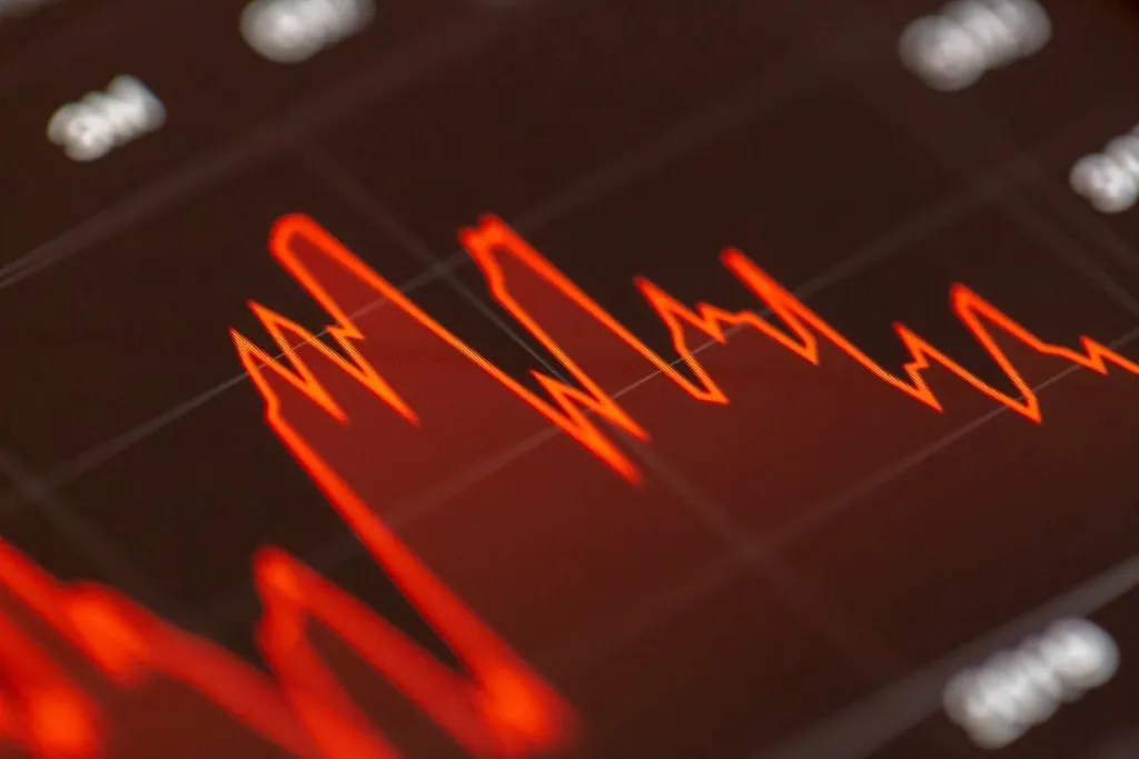 Red line chart of stock prices on a screen