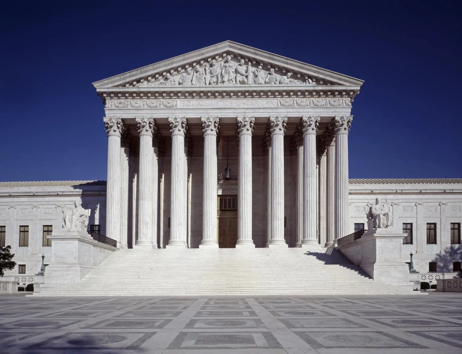 Columns and steps of the U.S. Supreme Court Building against a deep blue sky