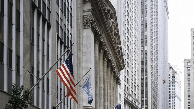 Wall Street in New York's Financial District with flags hanging from buildings